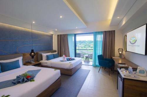 a hotel room with two beds and a balcony at Fairways and Bluewater Boracay in Boracay