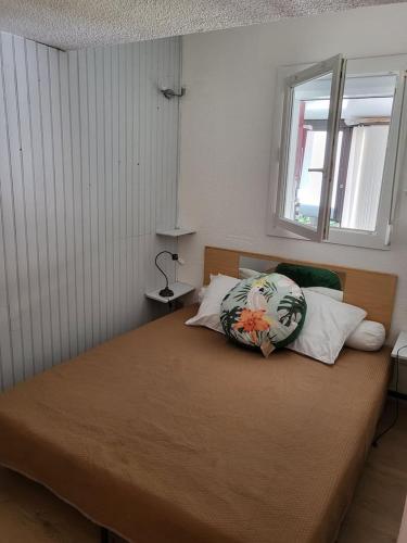 une chambre avec un lit avec un oreiller dessus dans l'établissement Petite maison proche plage !, à Saint-Cyprien