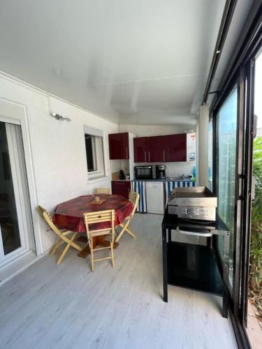 une cuisine et une salle à manger avec une table et des chaises dans l'établissement Petite maison proche plage !, à Saint-Cyprien