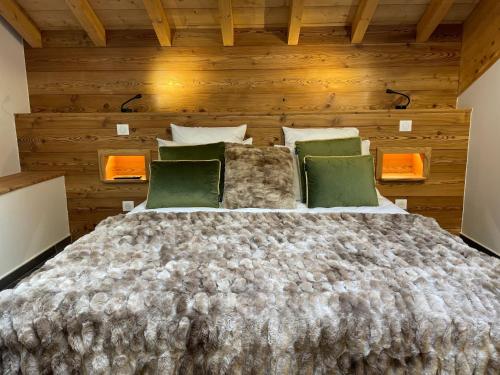 un grand lit dans une chambre aux murs en bois dans l'établissement Chalet Monthabor, à La Toussuire