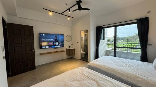 a bedroom with a bed and a flat screen tv at Tianshe Xiangsui B&B in Hualien City