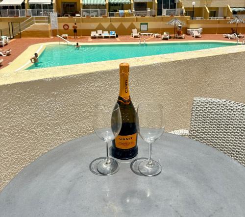 a bottle of champagne and two wine glasses on a table at Amazing Complex Costa Adeje Pool view & Relax in Adeje