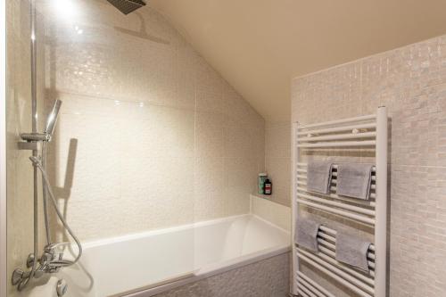 La salle de bains est pourvue d'une baignoire blanche. dans l'établissement Géranimus Versailles: Notre-Dame, à Versailles