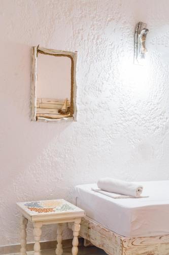a white bathroom with a mirror and a table at Brunis Apartments in Nei Poroi