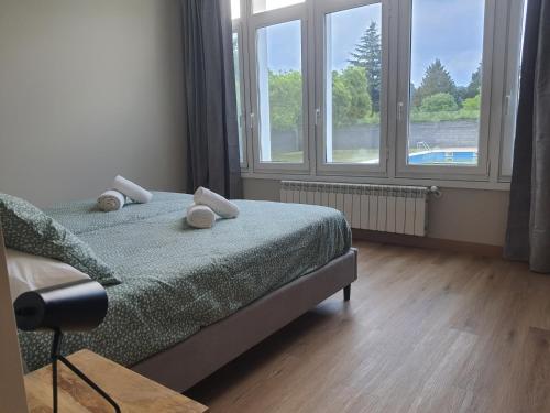 a bedroom with a bed and two windows at Pensión CREDENCIAL in Sarria