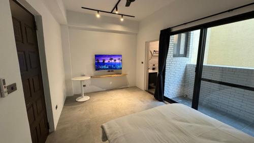 a bedroom with a bed and a tv on the wall at Tianshe Xiangsui B&B in Hualien City