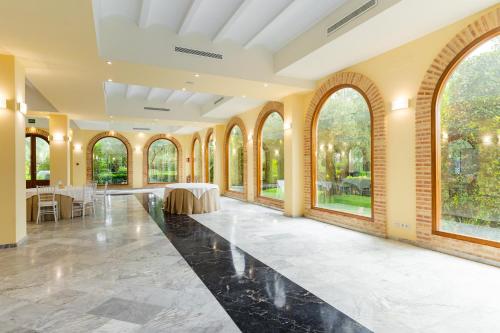 a large hall with large windows and a table in the middle at Ad Hoc Parque in Bétera