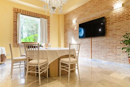 a dining room with a table and a tv on a brick wall at Ad Hoc Parque in Bétera