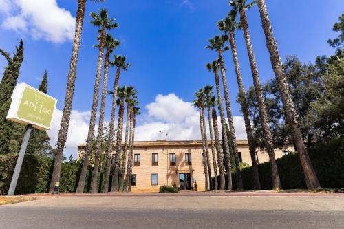 a row of palm trees in front of a building at Ad Hoc Parque in Bétera