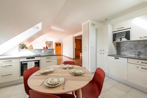 une cuisine avec une table en bois et des chaises rouges dans l'établissement Géranimus Versailles: Notre-Dame, à Versailles