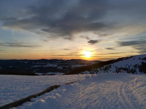 a sunset on top of a snow covered mountain at Hostal Orialde in Ochagavía