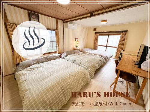 a row of beds in a room with a desk at Haru's House Onsen モール温泉付き in Shiraoi