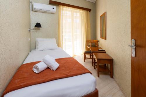 a hotel room with a bed with towels on it at Oelia Rooms & Apartments in Agia Marina Aegina