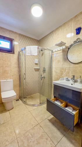 a bathroom with a shower and a sink and a toilet at Nilüfer Butik Otel in Ayvalık