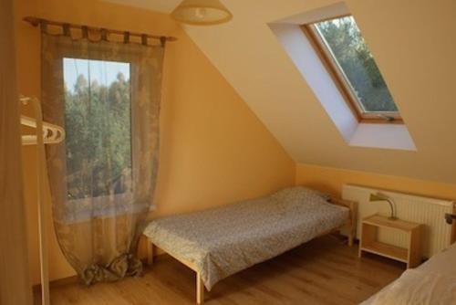 a bedroom with a bed and a window at Domek Jantar in Jantar