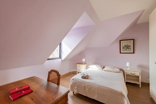 une chambre avec un lit et une table en bois dans l'établissement Géranimus Versailles: Notre-Dame, à Versailles