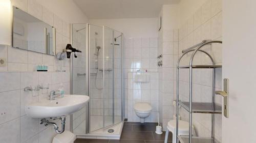 W łazience znajduje się umywalka, prysznic i toaleta. w obiekcie Apartmenthaus Binzer Sterne w mieście Binz
