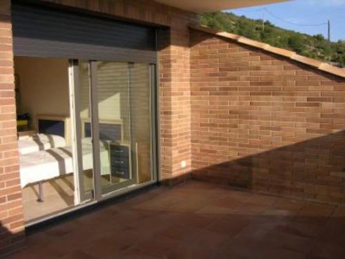 a patio with sliding glass doors on a brick building at Shambala B&B in Sitges