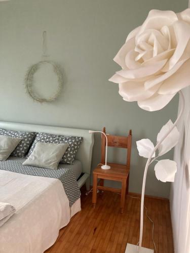 1 dormitorio con 1 cama y una flor blanca en Casa di kikka en Bassano del Grappa