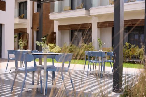 a patio with a table and chairs in front of a building at Falena Luxury Rooms in Kalyves Poligirou