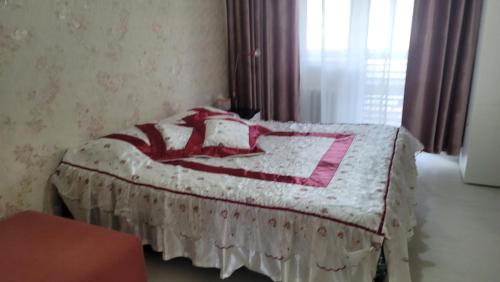 um quarto com uma cama com um cobertor rosa e branco em A nicely furnished, cozy apartment located in the center of the city with complimentary Mongolian traditional meal upon your arrival em Ulan Bator