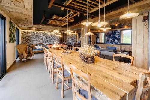 a dining room with a large wooden table and chairs at Le Col Panoramic in La Toussuire
