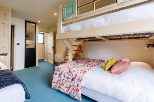 two beds in a room with two bunk beds at Le Col Panoramic in La Toussuire