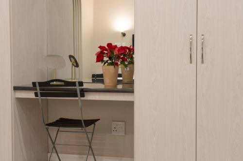 a room with a desk with a chair and flowers at Ruebys Apartment 202 in Dullstroom