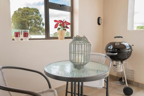 a glass table and chairs in a room with a window at Ruebys Apartment 202 in Dullstroom