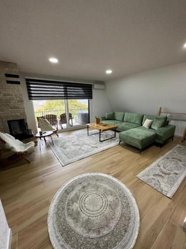 a living room with a green couch and a table at Vila Hasandić in Visoko