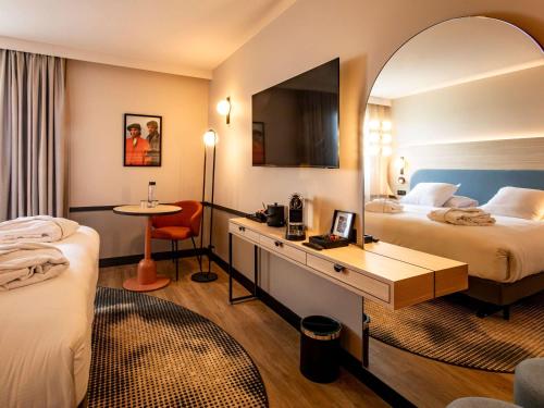 Cette chambre comprend deux lits et un bureau. dans l'établissement Mercure Angoulême Hôtel de France, à Angoulême