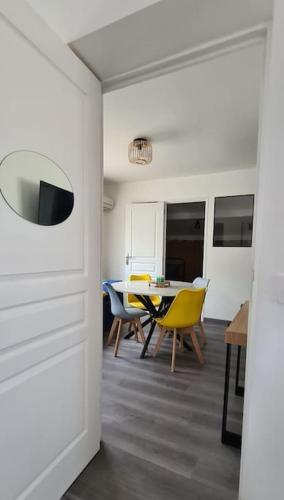 une salle à manger avec une table et des chaises jaunes dans l'établissement Appartement scandinave au soleil, à Baillargues