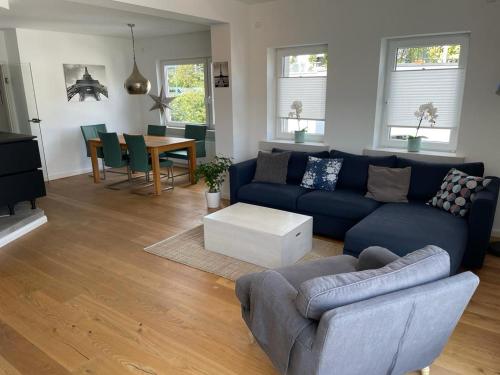 a living room with a blue couch and a table at Exklusives Apartment Nähe Attendorn und Olpe für 6 Personen mit Dachterasse in Attendorn