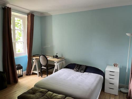 - une chambre avec un lit et un bureau dans l'établissement Appartement - Hotel particulier, à LʼÉtang-la-Ville