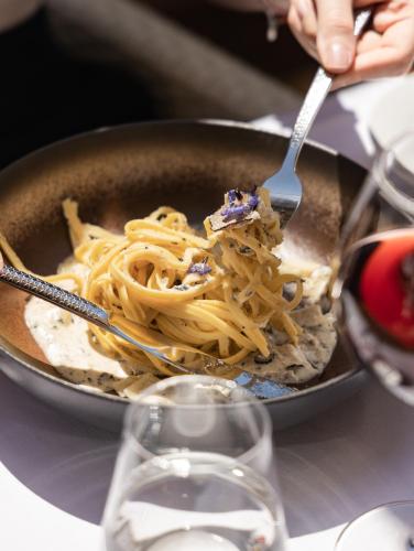 a person eating pasta with a fork in a pan at Boscolo Nice Hotel & Spa in Nice