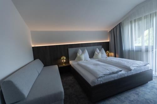 a bedroom with a large bed and a couch at WOHNEN by LIZZY in Wagrain