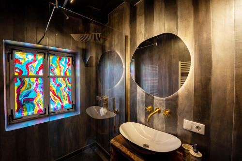 a bathroom with a sink and a stained glass window at Casa Albastră by Casa Otto in Sighişoara
