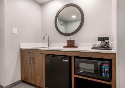 a kitchen with a microwave and a sink and a mirror at Hampton Inn & Suites Burlington in Burlington