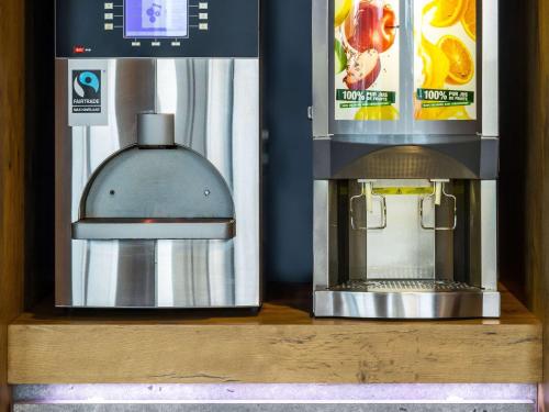 a coffee machine sitting on a wooden shelf next to a coffee maker at ibis budget Lyon Est Chaponnay in Chaponnay