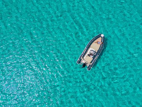an overhead view of a boat in the water at Calascoglietti in Stintino
