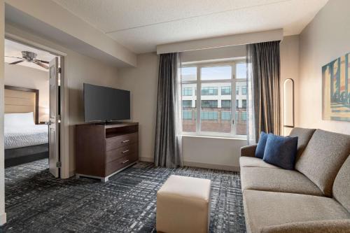 a hotel room with a couch and a tv and a bed at Homewood Suites by Hilton Washington, D.C. Downtown in Washington