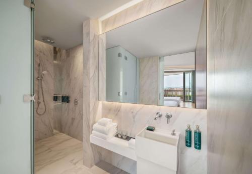 a white bathroom with a sink and a mirror at Hilton Pattaya in Pattaya Central