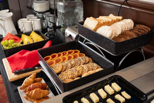 a buffet with trays of different types of bread and pastries at City Hotels Rūdninkai in Vilnius