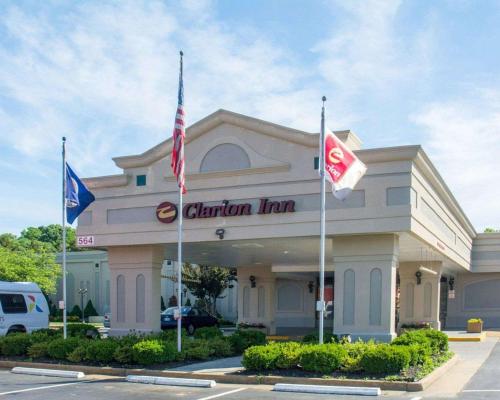 a clameland inn with flags in front of it at Clarion Inn Fredericksburg North in Fredericksburg