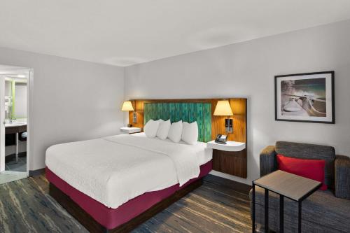 a hotel room with a large bed and a bathroom at Hampton Inn Bridgeport/Clarksburg in Bridgeport