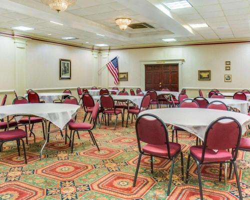 a conference room with tables and chairs and a flag at Clarion Inn Fredericksburg North in Fredericksburg