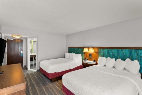 a hotel room with two beds and a desk at Hampton Inn Bridgeport/Clarksburg in Bridgeport