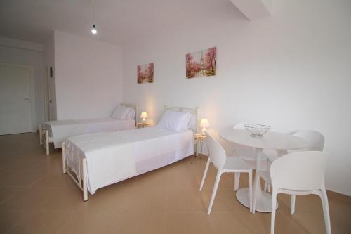 a bedroom with two beds and a table and chairs at Nefeli's Apartment in Himare