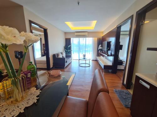 uma sala de estar com um sofá e uma mesa com flores em BV2 HotelSuite homestay 2 bedrooms KK City Centre Near Imago em Kota Kinabalu