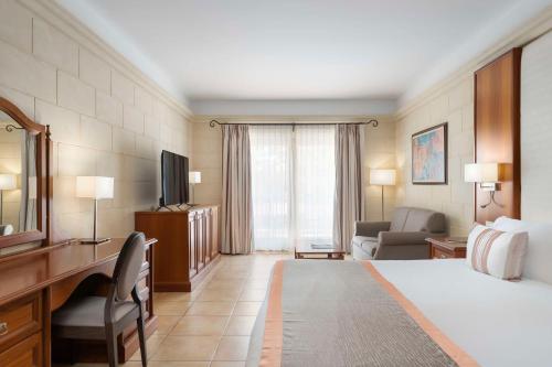 Habitación de hotel con cama y sala de estar. en Kempinski Hotel San Lawrenz en San Lawrenz